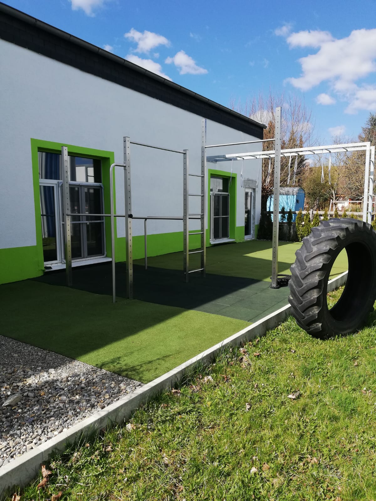 Outdoor-Bereich mit Klimmzuganlage und Trainingsreifen