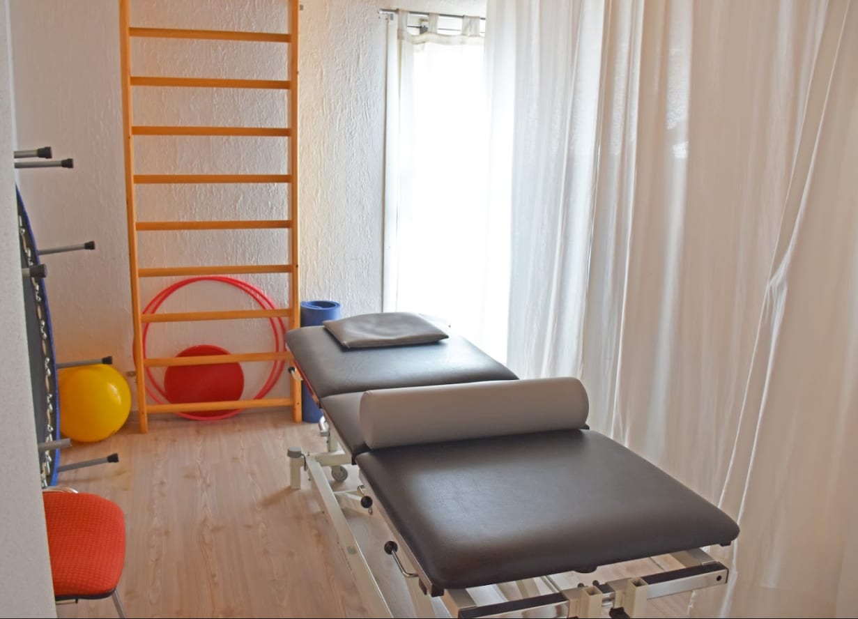 Behandlungsraum mit Therapieliegen und Sprossenwand