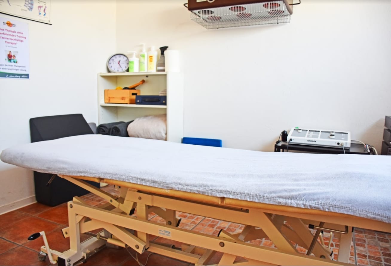 Behandlungsraum mit Therapieliege und Wärmelampe